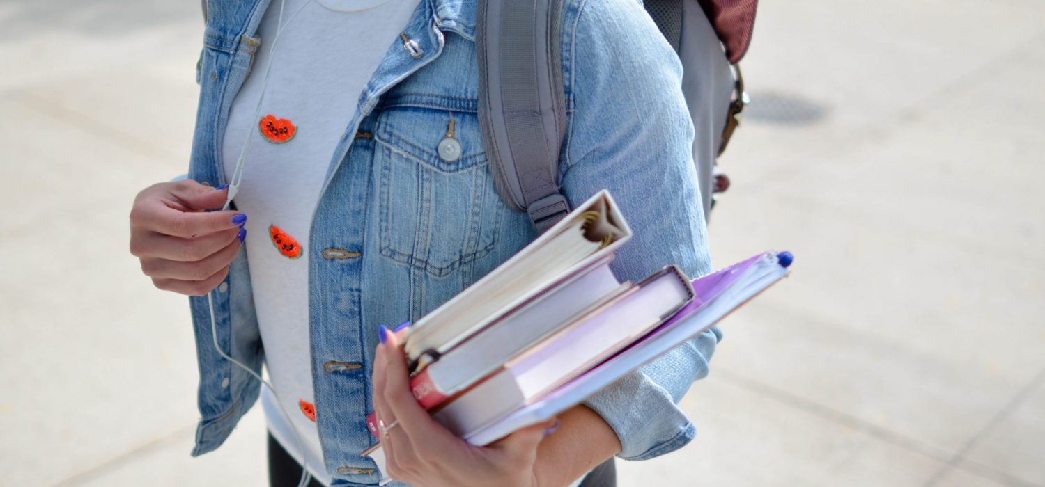 College student walking around campus with books